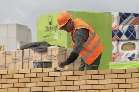 Zhytomyr, Ukraine - September 8, 2020: Workers laying bricks on construction site.のeditorial素材