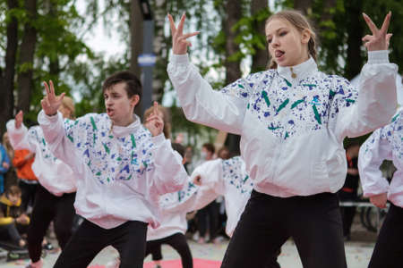 Zhytomyr, Ukraine - May 15, 2021: A group of people dancing on a square. Girls and boys raised their...