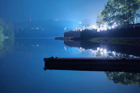 Lonely pier near the river coast at night.の写真素材