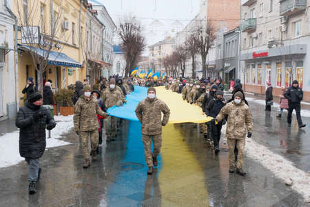 Zhytomyr, Ukraine - January 21, 2022: The military and children carries the longest flag in Zhytomyr.のeditorial素材