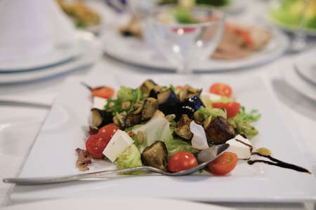 Greek salad with goat cheese with cherry tomatoes, pieces of California walnuts, lettuce sprouts and balsamic vinegarの写真素材