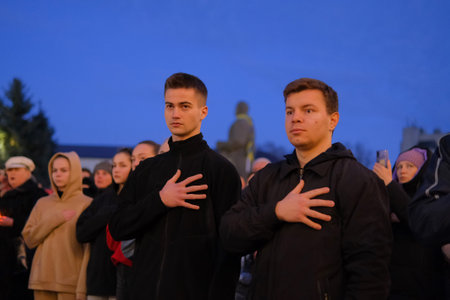 Zhytomyr, Ukraine - February 20, 2022: two young men put hands on their hearts in honor of people killed during the Revolution of Dignity.のeditorial素材