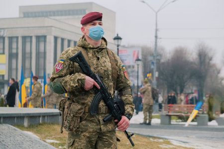 Zhytomyr, Ukraine - February 16, 2022: Armed soldier in medical mask guard the city.のeditorial素材