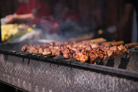 Roasting juicy meat steak with spices and herbs in burning charcoals fire on bbq grid, flames and...