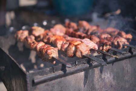 Roasting juicy meat steak with spices and herbs in burning charcoals fire on bbq grid, flames and smoke. Juicy steak with grilling stripes ready for picnic celebration. Barbecue grillの写真素材