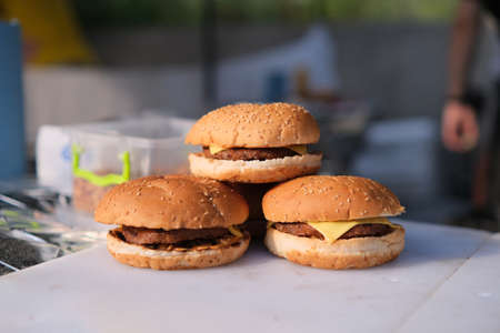 Homemade delicious three mini burgers served with salad, sauce and french fries.の写真素材
