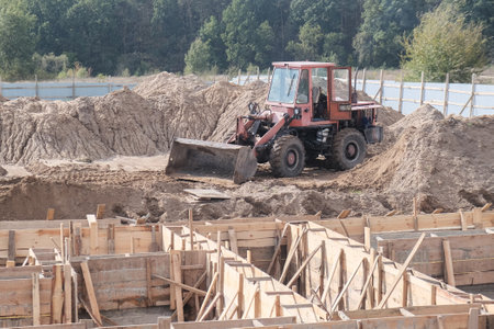 Wheel loader machine unloading soil during earthmoving works at construction site.の写真素材
