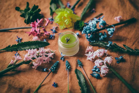 Spring floral background, texture with a jar of cosmetic cream at center of composition.の写真素材