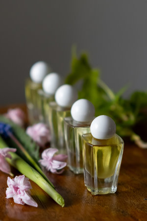 Female perfume bottle on the table with green branch and flowersの写真素材