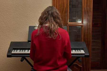 girl playing piano in her houseの写真素材