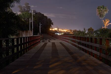 Marbella promenade at night in wood pathの写真素材