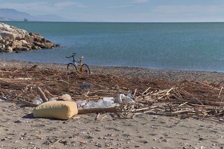 Spilled garbage on the beach of the big city. Empty used dirty plastic bottles. Dirty sea sandy shore the Black Sea. Environmental pollution. Ecological problem. Moving waves in the backgroundの写真素材
