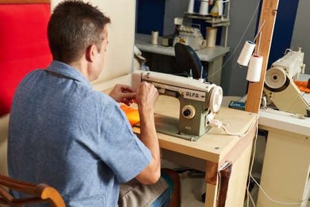 Qualified workman upholstering furniture in repair furniture workshop