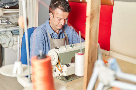 Qualified workman upholstering furniture in repair furniture workshop