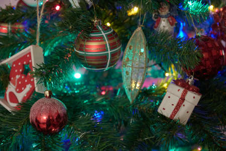 Christmas decorations on xmas tree with hanging balls and ornaments and bokeh background.