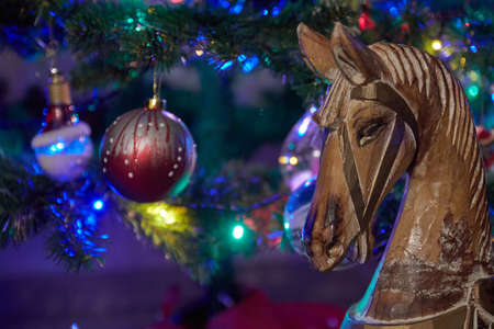 Wooden g \ horse close to christmas tree ornaments