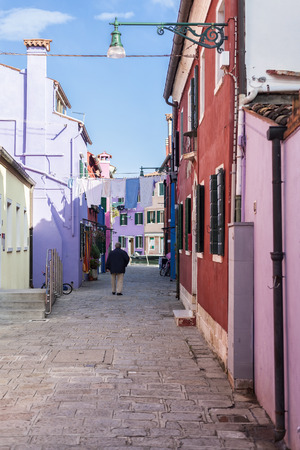 Old man in an alley in Burano, Veniceの写真素材