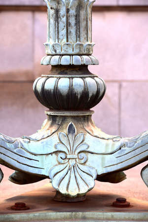 A close up of the base of an old art deco lamp post on an old building.の写真素材