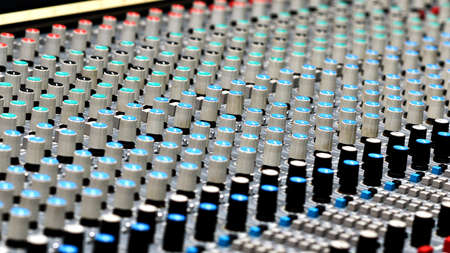 A close up of a large studio audio mixing console.