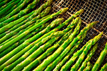 Asparagus in a stainless steel basket cooking on a grill.の写真素材