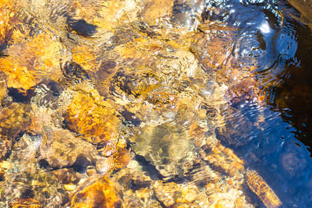 The abstract design created by the blurred view of rock on the bottom of a mountain stream.