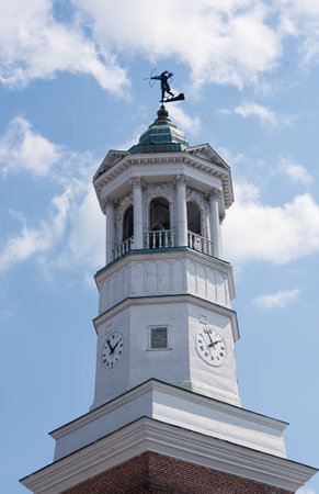 A close up of the historic clock tower in Camden, South Carolina, USA, with a blue sky background.