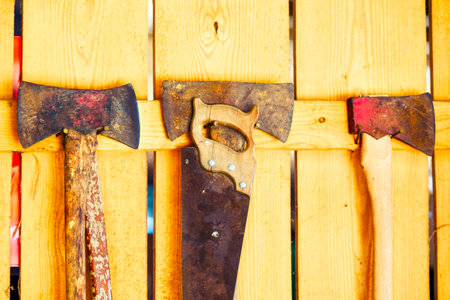 Old rusty axes on a wooden background. Old ax on a wooden background. Saw.の写真素材
