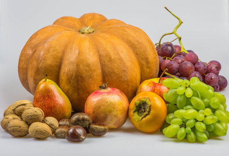 Still life, autumn food on white background - Pumpkin, chestnuts, walnuts, persimmon, peer, apple, pomegranate, grapesの写真素材