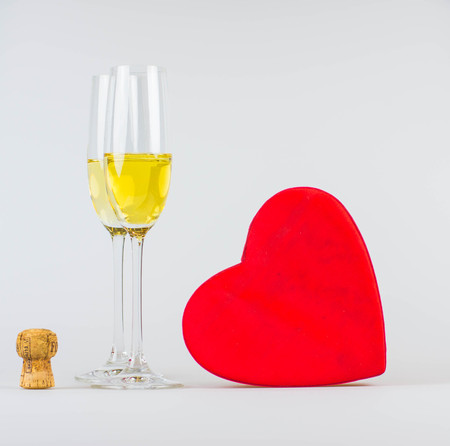 Happy valentines day greeting card with red heart and flutes of champagneの写真素材