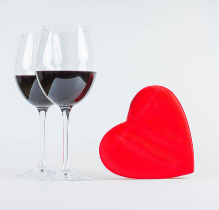 Happy valentines day greeting card with red heart and glasses of red wineの写真素材