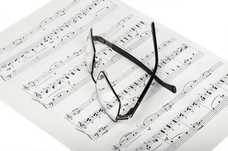 Sheet music and glasses isolated on whiteの写真素材