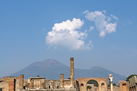 The temple of Jupiter in Pompeii with Mount Vesuvius lying dormant in the background. The city of Pompeii is a partially buried Roman town-city near modern Naples in the Italian region of Campania. Pompeii was destroyed and completely buried during a longのeditorial素材