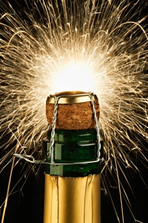 A bottle of champagne on a black background with sparklers の写真素材