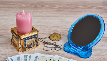 Everything is ready for divination - pack of Tarot cards, pentacle medallion, candle in  Egyptian candlestick, mirrorの写真素材