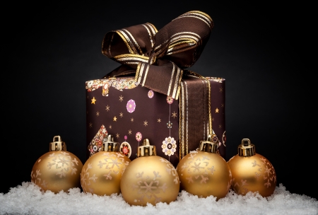Gold christmas balls with snow isolated on blackの写真素材
