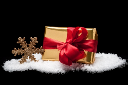 Golden christmas gift in snowの写真素材
