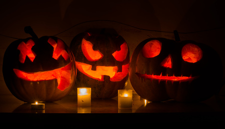 Halloween pumpkins with scary face and burning candle の写真素材
