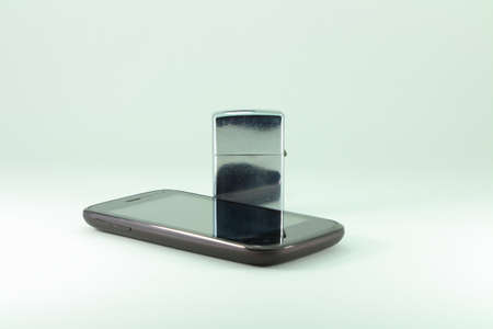 Classic lighter and the mobile phoneの写真素材