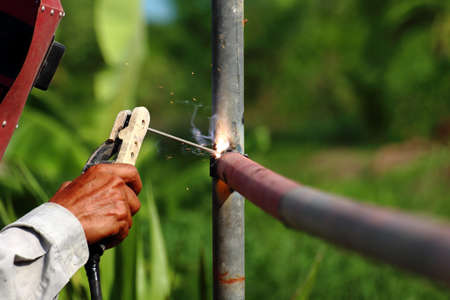 A man weld the pipes together