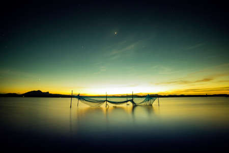 Long exposure shot of the net in the river with the last lightの写真素材