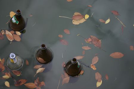 empty bottles drifting in water, concept: pollutionの写真素材
