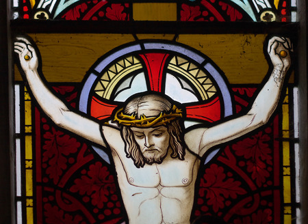 detail of victorian stained glass church window in Fringford depicting Jesus nailed to the crossのeditorial素材