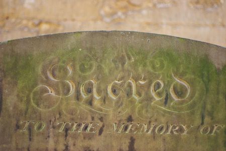 Grave stone with the word "sacred",  lot of stone texture visible.の写真素材