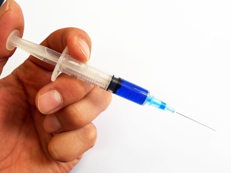 Syringe held by a handの写真素材