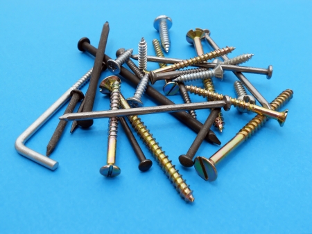 Screws and nails isolated on blue background の写真素材
