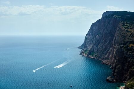 Rocks sea, the yacht goes along the wavesの写真素材