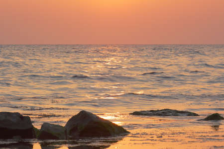 the sunset is bright over the blue seaの写真素材