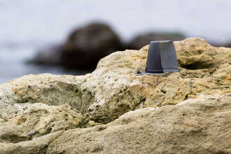 plastic garbage on the rocks on the seashoreの写真素材