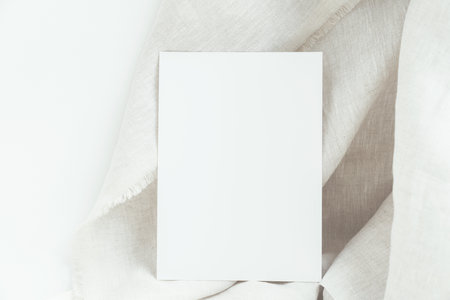 Blank white card mockup 5x7 wedding invitation card, rsvp, on white linen fabric background with copy space.の写真素材