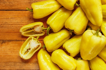 Mature whole pepper on wood background close-up, top viewの写真素材